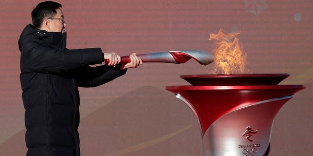 Chinese Vice Premier Han Zheng lights the torch before the start of the torch relay for the 2022 Winter Olympics at the Olympic Forest Park in Beijing on Wednesday, Feb. 2, 2022. 