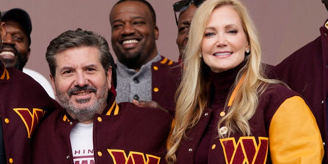 Dan and Tanya Snyder, co-CEOs of the Washington Commanders, pose for photos after unveiling their team's new identity in Landover, Maryland, on Feb. 2, 2022.