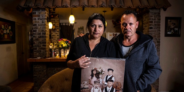 Erlinda Zacarias, left, and husband Jesus Mejia-Santana hold a portrait showing four of their six children who died on Saturday in "a mass casualty traffic collision" that killed multiple people in North Las Vegas on Monday, Jan. 31, 2022. 