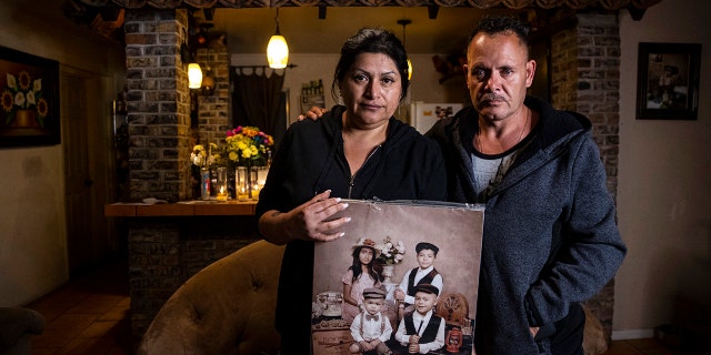 Erlinda Zacarias, left, and husband Jesus Mejia-Santana hold a portrait showing four of their six children who died on Saturday in "a mass casualty traffic collision" that killed multiple people in North Las Vegas on Monday, Jan. 31, 2022. 