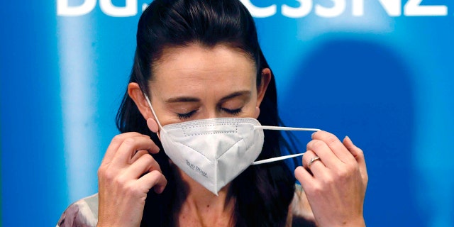 New Zealand Prime Minister Jacinda Ardern removes her mask before she outlines the government's plans, Thursday, Feb. 3, 2022, that will dismantle its quarantine system and reopen its borders the world. (Associated Press)