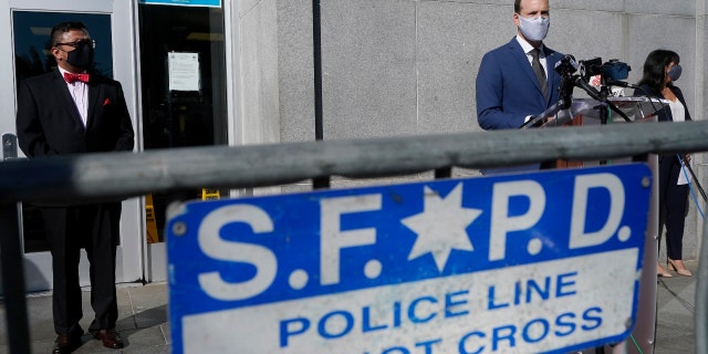 San Francisco District Attorney Chesa Boudin, foreground right, speaks between chief of staff David Campos, left, and assistant district attorney Rachel Marshall at a news conference in San Francisco, Nov. 23, 2020.