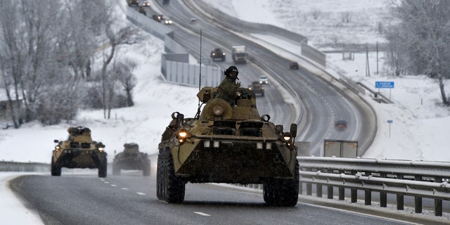A convoy of Russian armored vehicles moves along a highway in Crimea, Tuesday, Jan. 18, 2022.