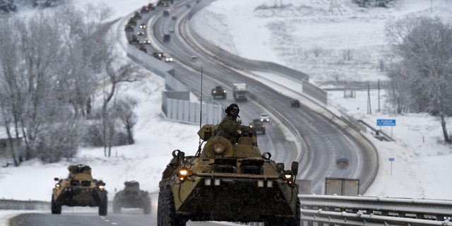 A convoy of Russian armored vehicles moves along a highway in Crimea, Tuesday, Jan. 18, 2022.