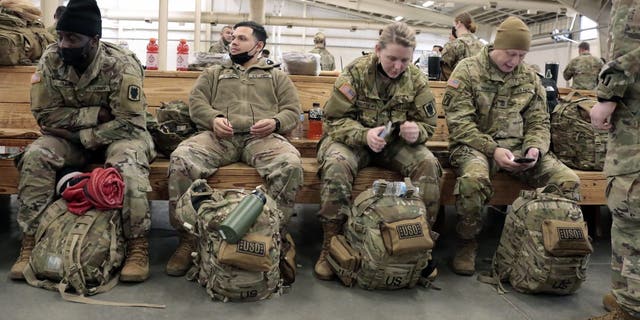 U.S. Army soldiers with the 18th Airborne Corps wait to board a plane for Europe Thursday, Feb. 3, 2022 from Fort Bragg, North Carolina.