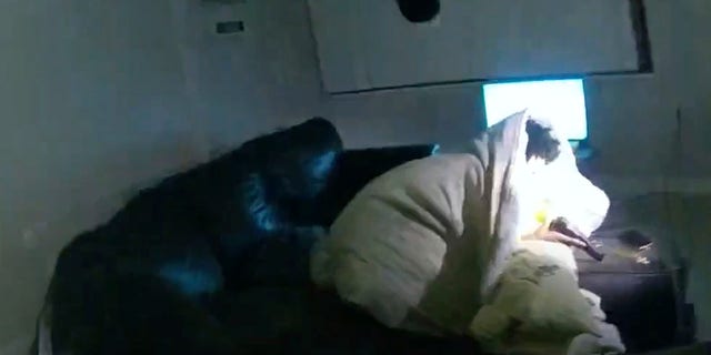 In this image taken from Minneapolis Police Department body camera video and released by the city of Minneapolis, 22-year-old Amir Locke wrapped in a blanket on a couch holding a gun moments before he was fatally shot by Minneapolis police as they were executing a search warrant in a homicide investigation on Wednesday, Feb. 2, 2022, in Minneapolis. 