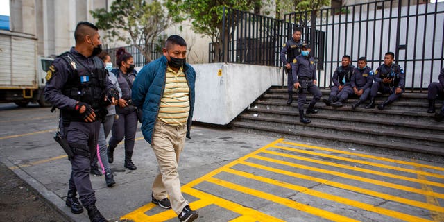 ICE teams up with Guatemala police to bust 10 suspected human smugglers linked to 19 murders 3 David Coronado Perez, who is alleged to be part of a human trafficking network, is being picked up by an officer in Guatemala City after his court hearing on Friday, February 4, 2022. (AP Photo / Oliver de Ross)