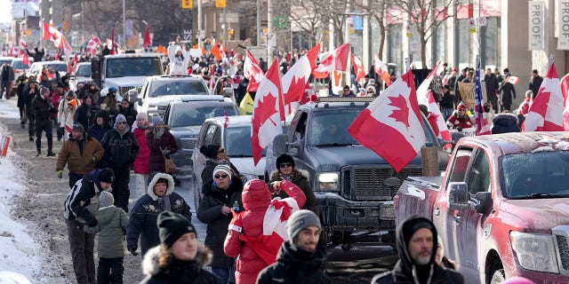 Trucks and supporters travel down Bloor Street during a demonstration in support of a trucker convoy in Ottawa protesting COVID-19 restrictions, in Toronto, Saturday, Feb. 5, 2022.