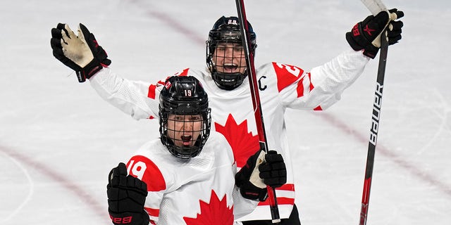 Canada's Brianne Jenner (19) celebrates with Marie-Philip Poulin (29) after Jenner scored a goal against the United States during a preliminary round women's hockey game at the 2022 Winter Olympics, Tuesday, Feb.  8, 2022, in Beijing. 