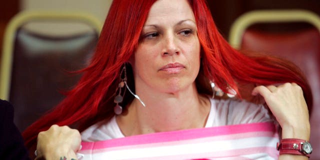 In this Dec. 13, 2004, file photo, Juror number 7, Richelle Nice, adjusts her hair as members of the jury speak with the media in the Old San Mateo County Courthouse in Redwood City, Calif. 