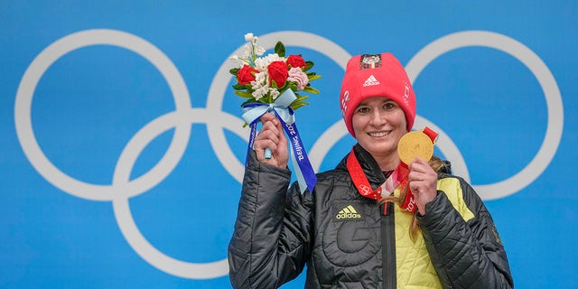 Natalie Geisenberger, of Germany, shows the gold medal at the podium for the luge women's singles at the 2022 Winter Olympics, Tuesday, Feb.  8, 2022, in the Yanqing district of Beijing. 