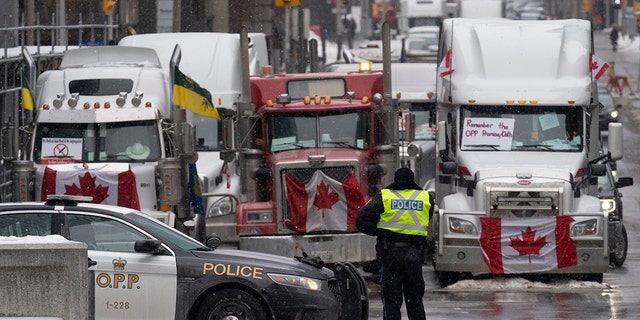 Police set up a barricade in front of cars parked as part of a truck protest on Tuesday, February 8, 2022, in central Ottawa.  (Adrian Wilde / The Canadian Press via AP)