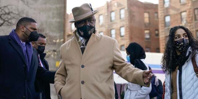 Attorney Ben Crump, center, prepares to speak at a news conference in the Bronx borough of New York, Tuesday, Feb. 8, 2022. Several families whose loved ones died while trying to escape a smoked-filled Bronx apartment building sued the building owners Tuesday, alleging safety violations that led to the wrongful deaths of 17 people, including eight children. (AP Photo/Seth Wenig)