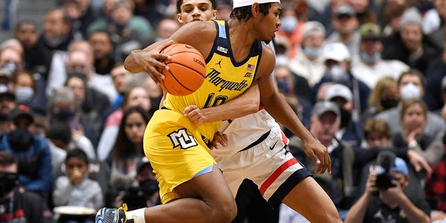 Marquette's Justin Lewis (10) is guarded by Connecticut's Andre Jackson in the first half of an NCAA college basketball game, Tuesday, Feb.  8, 2022, in Hartford, Conn.