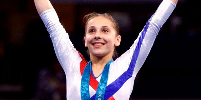 In this Thursday, Sept. 21, 2000 file photo, Andreea Raducan of Romania, receives her gold medal in the women's all-around gymnastics competition at the Olympics in Sydney, Australia. Raducan was the women's all-around gymnastics champ when the Romanian star tested positive for pseudoephedrine, which was contained in a cold remedy she got from the team doctor. 