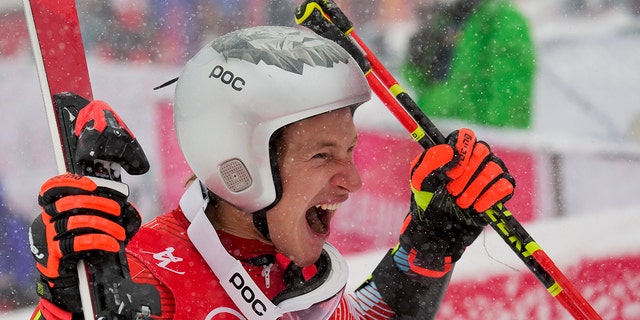 Marco Odermatt, of Switzerland, celebrates winning the gold medal in the men's giant slalom at the 2022 Winter Olympics, Sunday, Feb. 13, 2022, in the Yanqing district of Beijing. 