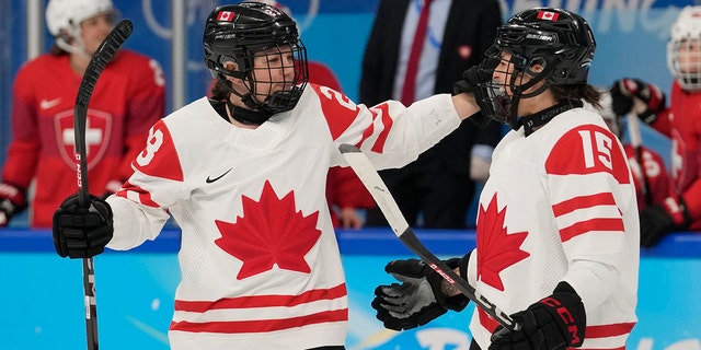 Canada's Erin Ambrose (23) and Melodie Daoust (15) celebrate after Ambrose scored a goal against Switzerland during a women's semifinal hockey game at the 2022 Winter Olympics, Monday, Feb. 14, 2022, in Beijing. 