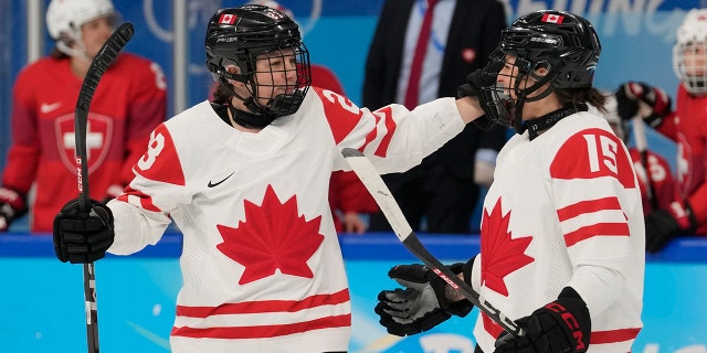 Canada's Erin Ambrose (23) and Melodie Daoust (15) celebrate after Ambrose scored a goal against Switzerland during a women's semifinal hockey game at the 2022 Winter Olympics, Monday, Feb. 14, 2022, in Beijing.