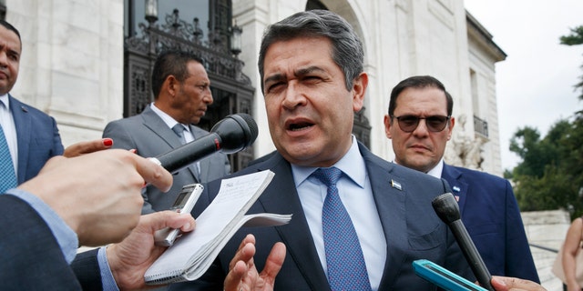 Honduran President Juan Orlando Hernandez answers questions from the Associated Press, Tuesday, Aug. 13, 2019, as he leaves a meeting at the Organization of American States, in Washington. 