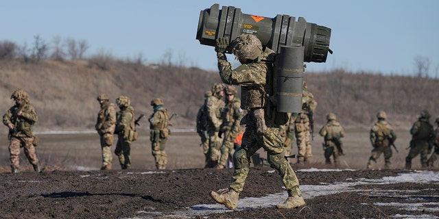 A Ukrainian serviceman carries an anti-tank weapon during a drill in Donetsk region, eastern Ukraine, February 15, 2022.