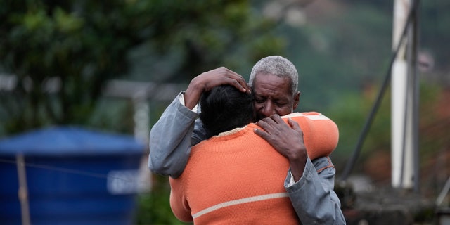 Residents embrace as they wait for a report for missing relatives in Petropolis, Brazil, Wednesday, Feb. 16, 2022.