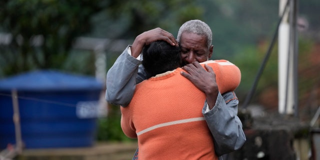 Residents embrace as they wait for a report for missing relatives in Petropolis, Brazil, Wednesday, Feb. 16, 2022.