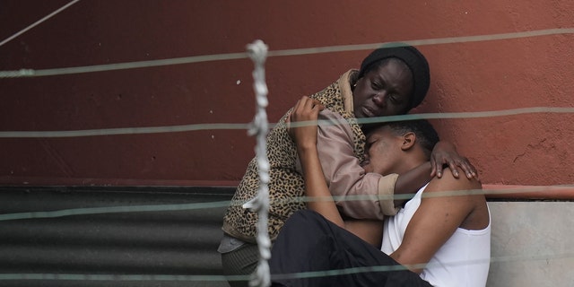 Residents embrace after fatal mudslides in Petropolis, Brazil, early Wednesday, Feb. 16, 2022.