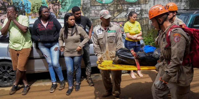 Rescue workers carry the body of a mudslide victim in Petropolis, Brazil, Wednesday, Feb. 16, 2022.