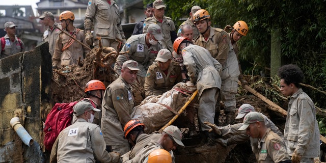 Rescue workers remove the body of a mudslide victim in Petropolis, Brazil, Wednesday, Feb. 16, 2022.