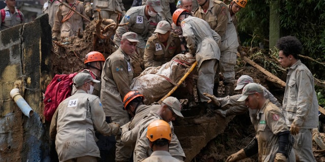 Rescue workers remove the body of a mudslide victim in Petropolis, Brazil, Wednesday, Feb. 16, 2022.