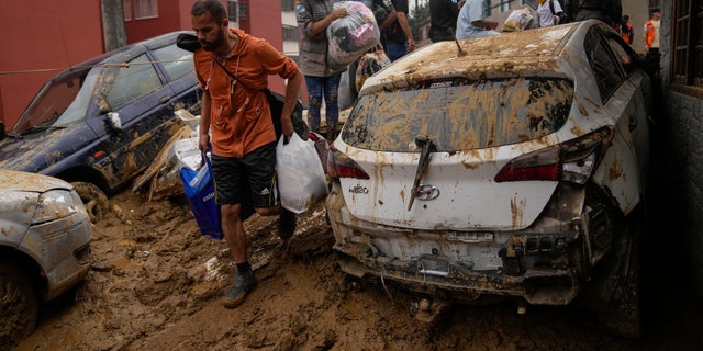 Residents recover belongings from their homes destroyed by mudslides in Petropolis, Brazil, Wednesday, Feb. 16, 2022.