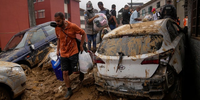Residents recover belongings from their homes destroyed by mudslides in Petropolis, Brazil, Wednesday, Feb. 16, 2022.