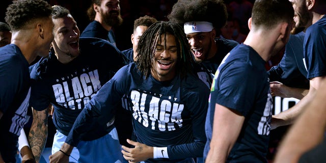 Memphis Grizzlies guard Ja Morant, center, is congratulated by teammates during a ceremony presenting Morant with a 2022 NBA All-Star jersey before an NBA basketball game against the Portland Trail Blazers Wednesday, Feb. 16, 2022, in Memphis, Tenn.