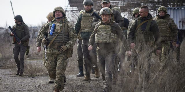 Ukrainian President Volodymyr Zelenskyy, center, pays a visit to the front line in the Donetsk region, eastern Ukraine, on Feb. 24, 2022.