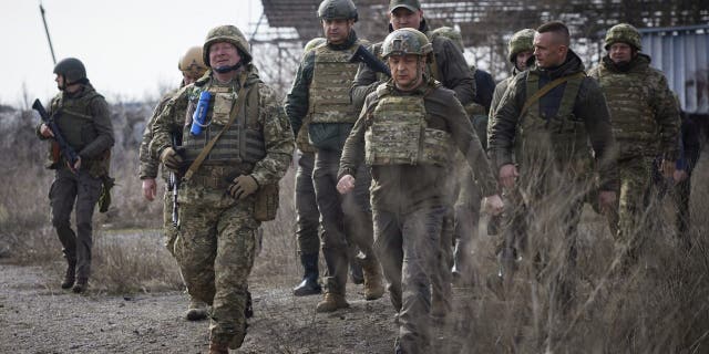 Ukrainian President Volodymyr Zelenskyy, center, visits the front line in Donetsk region, eastern Ukraine, Thursday, Feb. 17, 2022. 