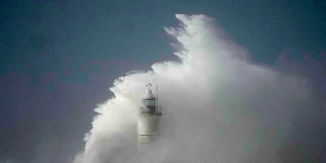 Waves crash over the Newhaven harbour breakwater and lighthouse, as Storm Eunice hits Newhaven, on the south coast of England, Friday, Feb. 18, 2022.