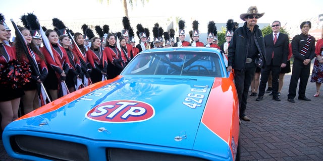 Richard Petty stands next to a replica race car before the NASCAR Daytona 500 auto race at Daytona International Speedway, Sunday, Feb. 20, 2022, in Daytona Beach, Fla. (AP Photo/Phelan M. Ebenhack)
