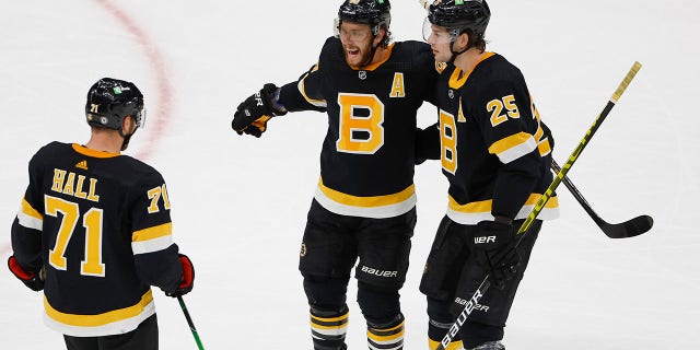 The Boston Bruins' David Pastrnak, center, is congratulated by Brandon Carlo (25) and Taylor Hall (71) after scoring against the Colorado Avalanche during the second period Feb. 21, 2022, in Boston.