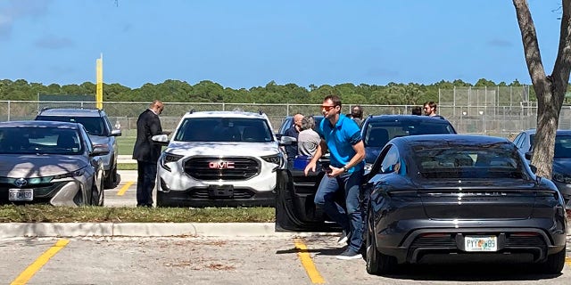 New York Mets pitcher Max Scherzer gets out of his car as he arrives for baseball labor talks at Roger Dean Stadium in Jupiter, Fla., Wednesday, Feb. 23, 2022. At far left is Major League Baseball Players Association executive director Tony Clark.