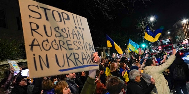 Demonstrators hold placards and flags as they attend a protest outside the Russian Embassy, in London, Wednesday, Feb. 23, 2022. Ukraine urged its citizens to leave Russia as Europe braced for further confrontation Wednesday after Russia's leader received authorization to use military force outside his country and the West responded with a raft of sanctions.
