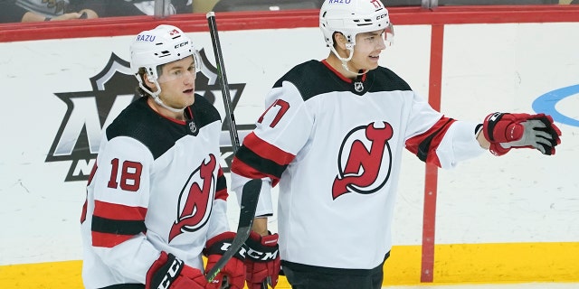 New Jersey Devils' Yegor Sharangovich, right, celebrates beside teammate Dawson Mercer (#18) after scoring against the Pittsburgh Penguins during the first period of an NHL hockey game, Thursday, Feb. 24, 2022. The Devils' logo is a play on the urban legend.