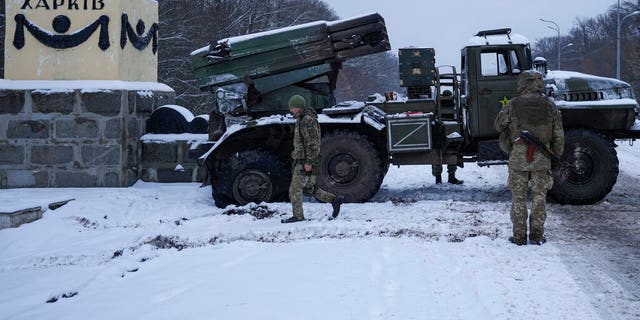 Ukrainian service members walk by a deactivated Russian military multiple rocket launcher on the outskirts of Kharkiv, 우크라이나, 금요일, 2 월. 25, 2022. 
