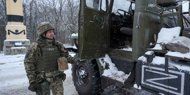 A Ukrainian serviceman opens the door of a deactivated Russian military multiple rocket launcher on the outskirts of Kharkiv, Ukraine, on Friday, Feb. 25, 2022. Russian troops bore down on Ukraine's capital Friday, with gunfire and explosions resonating ever closer to the government quarter, in an invasion of a democratic country that has fueled fears of wider war in Europe and triggered worldwide efforts to make Russia stop.