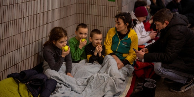 A family sits in the Kyiv subway, using it as a bomb shelter in Kyiv, Ukraine, on Friday, Feb. 25, 2022. In Ukraine's capital, many residents hurried underground for safety overnight Thursday and Friday as Russian forces fired on the city and moved closer. 