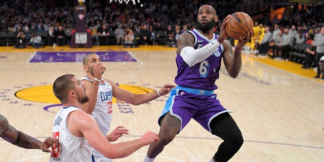 Los Angeles Lakers forward LeBron James, right, shoots as Los Angeles Clippers center Ivica Zubac, left, and forward Nicolas Batum defend during the first half of an NBA basketball game Friday, Feb. 25, 2022, in Los Angeles.