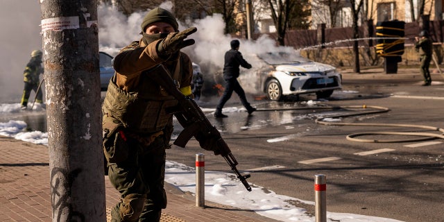 Ukrainian soldiers take positions outside a military facility