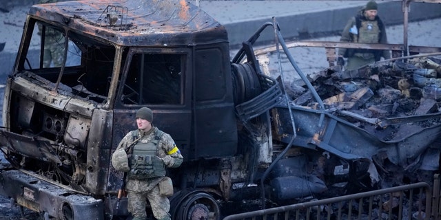 Ukrainian troops inspect the site following a Russian airstrike in Kiev, Ukraine, Saturday February 26, 2022. 