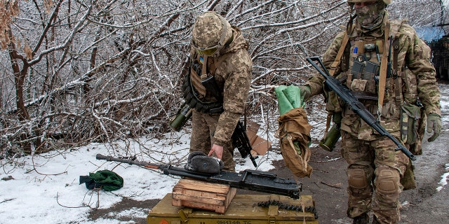 Ukrainian soldiers handle equipment outside Kharkiv, Ukraine, Saturday, Feb. 26, 2022.