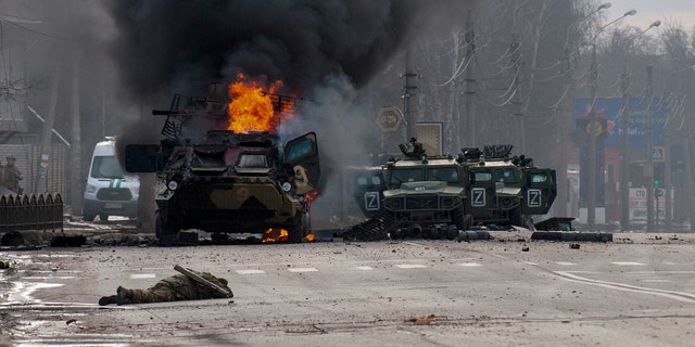 An armored personnel carrier burns and damaged light utility vehicles stand abandoned after fighting in Kharkiv, Ukraine, on Sunday. The city authorities said that Ukrainian forces engaged in fighting with Russian troops that entered the country's second-largest city on Sunday.