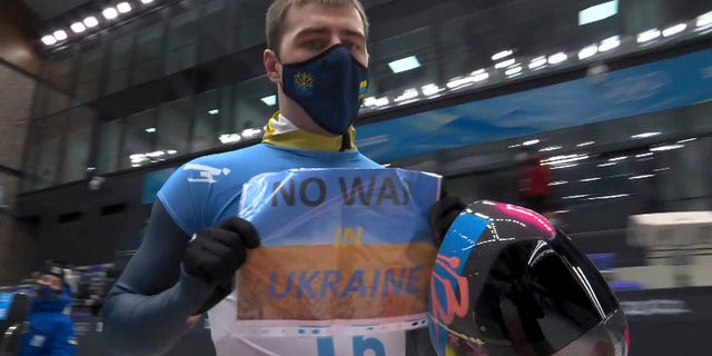FILE - In this frame from video, Vladyslav Heraskevych, of Ukraine, holds a sign that reads 